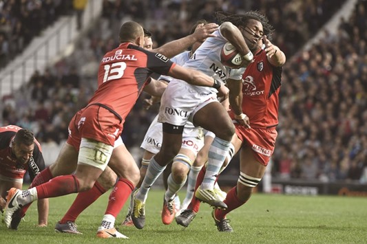 Racing Metro 92 Fidjian centre Albert Vulivuli (centre) is tackled by Toulouse players during the French Top 14 rugby union match in Toulouse, southern France. (AFP)