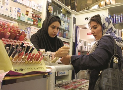 An Iranian woman tests the colours of make-up at an upscale shop in north Tehran (file). Even under sanctions, independent shops in the affluent northern districts of Tehran managed to obtain the latest seasonal collections of top global brands such as Dolce & Gabbana, Louis Vuitton, Gucci, and Roberto Cavalli.
