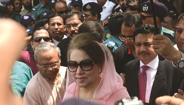 Khaleda Zia, centre, walking as she left after a court appearance in Dhaka yesterday.