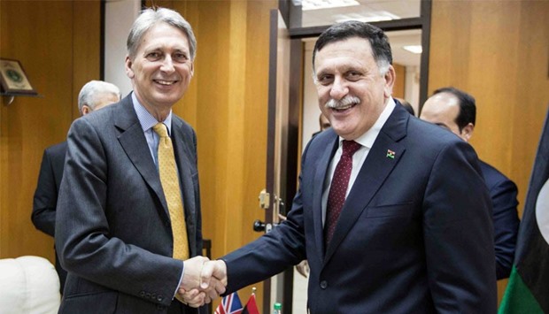 A handout pictures made available on the official Facebook media page of Fayez al-Sarraj, prime minister of the UN-backed unity government, shows him (R) meeting with British Foreign Secretary Philip Hammond. AFP