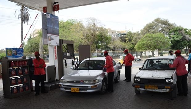 Pakistani attendants fill vehicles at a petrol station in Karachi on Monday. Oil prices plunged in Asia sending energy stocks tumbling after the collapse of talks among the world's top oil producers to cap output and ease a global supply glut.