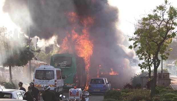 Flames rise at the scene where an explosion tore through a bus in Jerusalem yesterday setting a second bus on fire, in what an Israeli official said was a bombing, yesterday.
