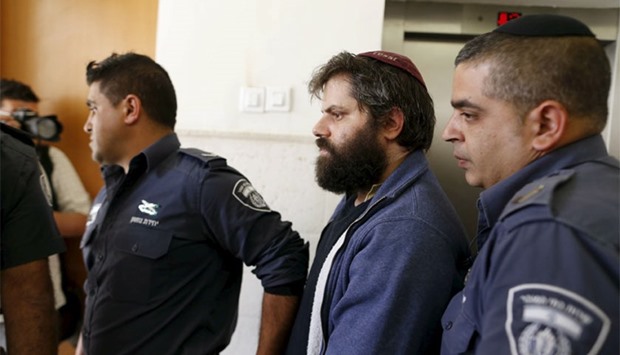 Yosef Haim Ben-David, (C) who was convicted of murdering a Palestinian teenager in Jerusalem, is led out of the courtroom by Israeli prison guards at Jerusalem's District Court. Reuters