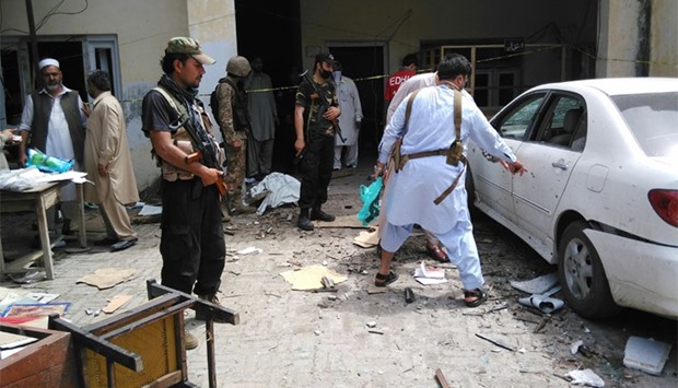 Pakistani security officials inspect the site of a suicide bomb attack on a government building in Mardan, about 50 kilometres northeast of the region's main city of Peshawar