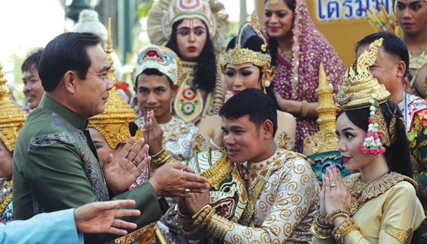 Thailandu2019s Prime Minister Prayut Chan-O-Cha greets traditional dancers as he arrives for a weekly cabinet meeting at Government House in Bangkok yesterday.