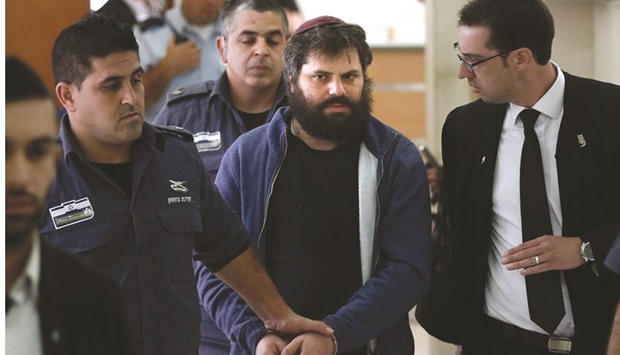 Israeli Yosef Haim Ben-David (centre), the ringleader of the killing of Palestinian teenager Mohamed Abu Khdeir last year, is escorted by Israeli policemen at the district court in Jerusalem yesterday.