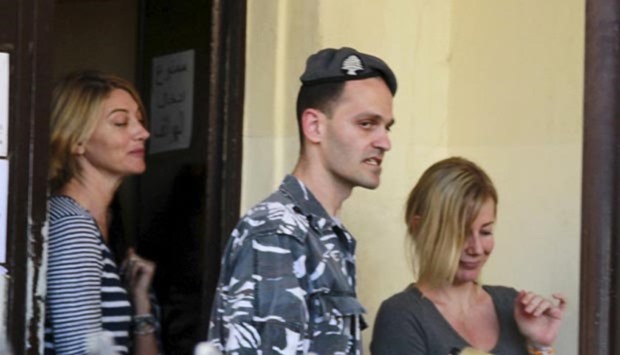 A policeman escorts Australian Sally Faulkner (right), the mother of the children, and Australian reporter Tara Brown, upon their release from Lebanon's Baabda prison for women on Wednesday.