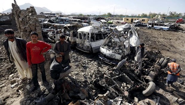 Residents stand at the site of a suicide car bomb attack on a government security building in Kabul, on Wednesday.