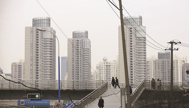 People walking on a bridge near the financial district of Pudong in Shanghai. The Chinese economyu2019s major demand-side driver, real-estate investment, is declining more rapidly than the alternative source of demand, domestic consumption, is rising. In 2015, the unsold residential floor space for China as a whole was 700mn square metres (7.5bn square feet), while the average annual sale of floor space in normal times was 1.3bn square metres.
