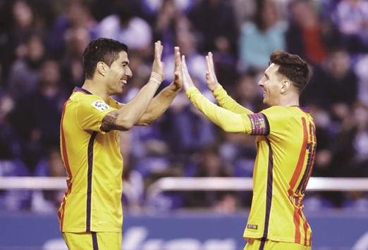 Barcelonau2019s Lionel Messi (R) celebrates his goal against Deportivo Coruna with team mate Luis Suarez in Coruna yesterday.
