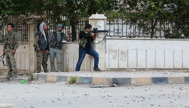 Kurdish fighters take position during clashes with Syrian pro-government in the northwestern Syrian