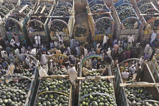 Farmers gather at a fruit market to sell watermelons in Lahore yesterday.