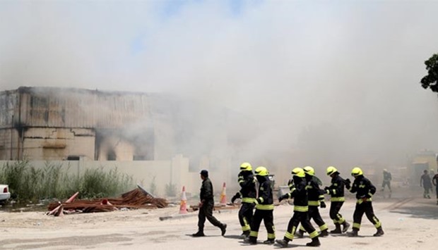 Civil Defence personnel at work near the complex on Street 30 where the fire broke out yesterday. PICTURES: Jayaram