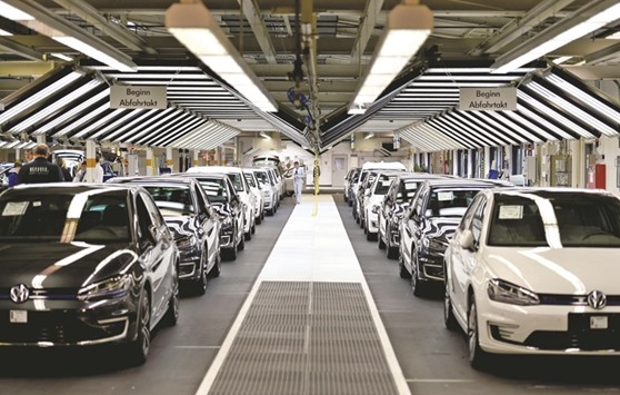 Employees of German carmaker Volkswagen checking cars at an assembly line in Wolfsburg, central Germany. The embattled auto giant looks to have struck a deal with US authorities over compensation for car owners in its massive engine-rigging scandal, according to a newspaper report yesterday.