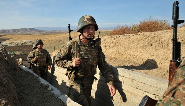This file photo taken on October 26, 2012 shows Armenian soldiers of the self-proclaimed republic of Nagorno-Karabagh walking in trenches at the frontline on the border with Azerbaijan.
