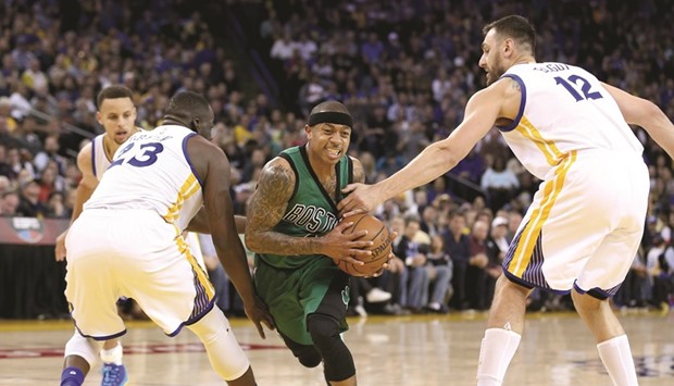 Isaiah Thomas (C) of the Boston Celtics drives between Draymond Green and Andrew Bogut (R) of the Golden State Warriors at ORACLE Arena in Oakland, California. (Getty Images/AFP)