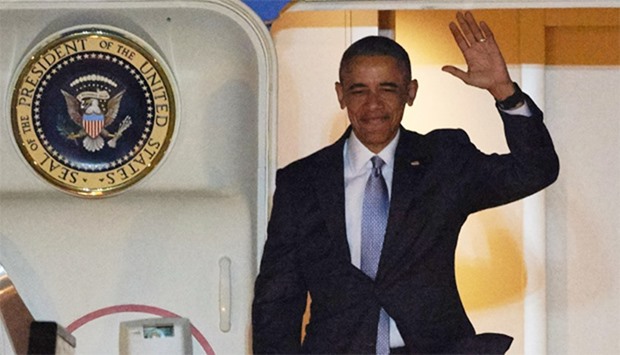 US President Barack Obama waves as he exits Air Force One after landing at Stansted Airport in Londo