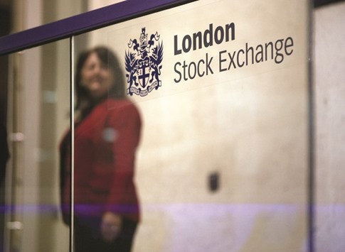 A visitor passes a sign inside the London Stock Exchange. The FTSE 100 index closed down 1.1% to 6,310.44 points yesterday.