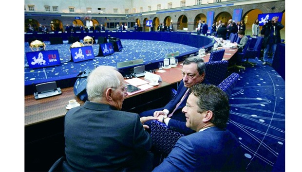 German Finance Minister Wolfgang Schauble (left), ECB President Mario Draghi (right), and Dutch Finance Minister Jeroen Dijsselbloem talk during the meeting of the eurozone ministers in Amsterdam. Lenders asked Greece yesterday to prepare a package of additional savings measures which would be passed into law now but implemented only if needed, to make sure the country reaches agreed fiscal targets.