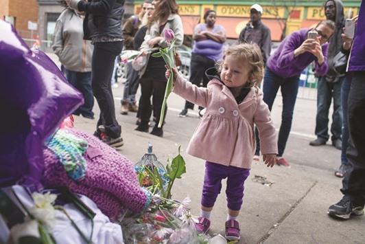 Hartley Hokuf leaves a flower at a memorial to Prince outside the First Avenue nightclub in Minneapolis, Minnesota, yesterday.