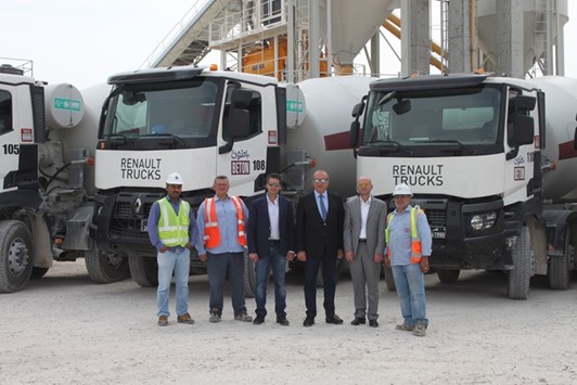 Officials standing in front of some Renault Trucks models.