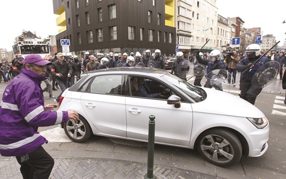 Belgian police try to stop a car driving towards a police road block before the driver tried to speed off and crashed into a woman on the street in the Brussels district of Molenbeek.