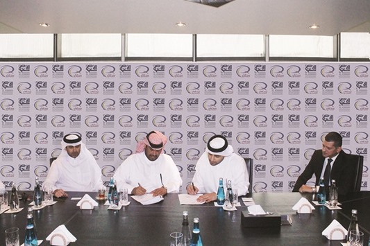 Al Asmakh and Qatar Post officials sign the agreement.