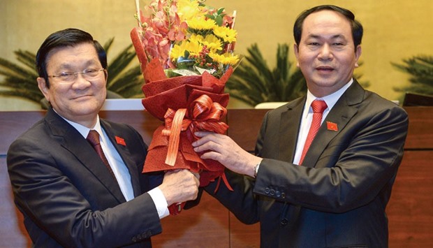 Vietnamu2019s newly elected President Tran Dai Quang (right) is greeted by his predecessor Truong Tan Sang after he was elected the countryu2019s new president by the National Assembly during a ceremony at Parliament House in Hanoi yesterday.