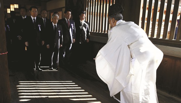 A Shinto priest welcomes Japanese lawmakers during their visit to the Yasukuni shrine in Tokyo.