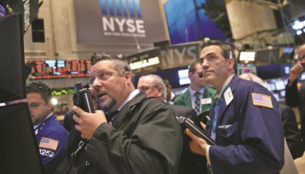 Traders work at the New York Stock Exchange (file). Even with a spate of high-profile earnings disappointments in recent days from the likes of Caterpillar, Microsoft and Googleu2019s parent company, the profit recession that has dogged US stocks since last fall is still expected to come to an end in the second half of this year.