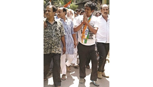 Former footballer and Trinamool Congress candidate Dipendu Biswas greets supporters as he conducts a door-to-door campaign in Basirhut of North 24 Parganas on Friday.