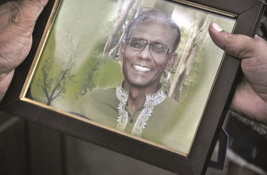 A man holds a portrait of professor Rezaul Karim Siddique, who was hacked to death by unidentified attackers, in Rajshahi yesterday.