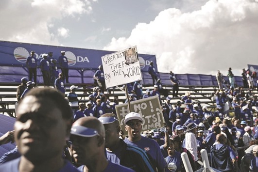 Democratic Alliance supporters hold banners mocking South African President Jacob Zuma at the official u2018Municipal Elections Party Manifestou2019 launch at the Rand Stadium in Johannesburg.