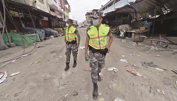 Ecuadorean policemen guard the devastated Tarqui suburb of Manta town