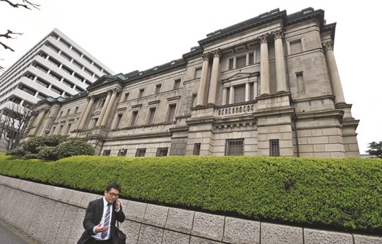 A businessman walks past the headquarters of the Bank of Japan in Tokyo. With most of Japanu2019s bonds offering negative yields and the BoJ cornering a third of the market as part of its unprecedented stimulus, strategists say the government with the worldu2019s biggest debt pile will have no trouble selling more as investors hunt any notes that can be traded and offer a return.
