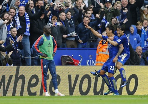 Leonardo Ulloa celebrates with Shinji Okazaki after scoring the second goal for Leicester City as Swansea substitute Madou Barrow (left) looks on dejected yesterday. (Reuters)