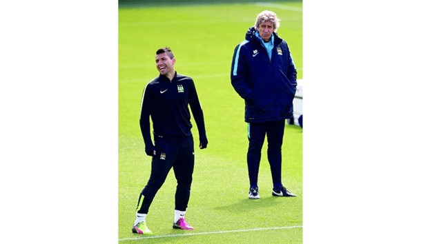 Manchester Cityu2019s manager Manuel Pellegrini (right) looks on as striker Sergio Aguero laughs during a training session yesterday. (AFP)