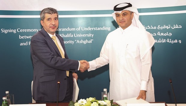 Dr Ahmad Hasnah and Nasser Ali al-Mawlawi shaking hands after signing a memorandum of understanding.