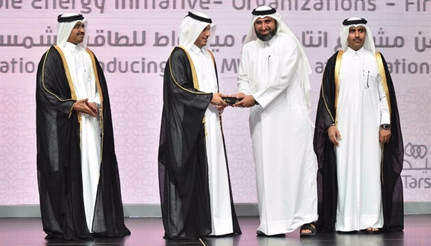 HE the Prime Minister and Interior Minister Sheikh Abdullah bin Nasser bin Khalifa al-Thani presenting the awards to a QF official as HE the Minister of Energy and Industry Dr Mohamed bin Saleh al-Sada and Kahramaa president Essa bin Hilal al-Kuwari look on.