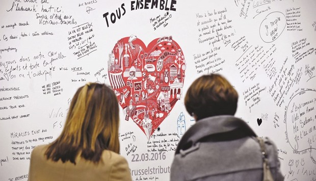 People read messages on a commemorative wall at the Maalbeek metro station after it reopened yesterday.