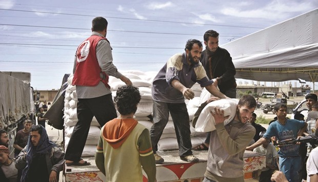 Syrians unload boxes from a lorry after an aid convoy of the International Committee of the Red Cross (ICRC) and the Syrian Arab Red Crescent entered the rebel-held town of Rastan, in central Homs province, yesterday. Relief groups began their second major aid delivery in a week to tens of thousands of besieged people in central Syria. Thirty-five aid trucks would be delivered to Rastan and surrounding rural areas, said International Committee of the Red Cross spokesman Pawel Krzysiek.