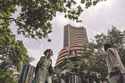Pedestrians walk past the Bombay Stock Exchange building in Mumbai. The Sensex closed up 1.3% yesterday, reclaiming the 26,000 mark for the first time since December-end.