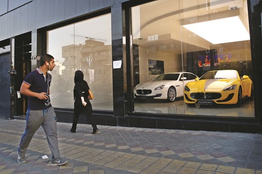 A pedestrian looks in the window of a Maserati luxury automobile showroom displaying a yellow Gran Cabrio Sport in Tehran (file). Last yearu2019s nuclear deal between Iran and six countries brought an end to a decade-long sanctions regime that had isolated the countryu2019s financial markets. President Hassan Rouhani has made supporting the private sector and capital markets a top priority of his economic reform agenda as he seeks foreign investment for tens of billions of dollars worth of infrastructure projects.