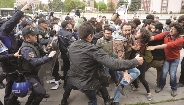 Riot police use tear gas to disperse demonstrators during a protest against parliament speaker Ismail Kahraman (above), outside the Turkish parliament in Ankara.