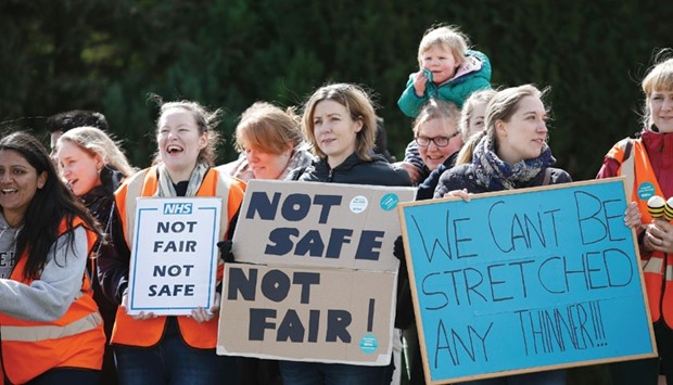 Junior doctors hold placards as they protest outside the Basingstoke and North Hampshire Hospital, in Basingstoke, west of London, yesterday.