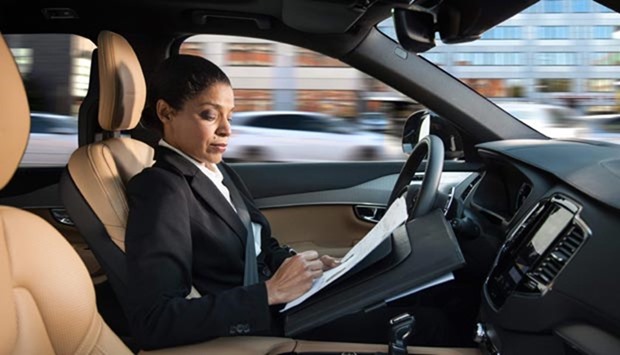A woman reads inside an autonomous driving car in this handout picture provided by Swedish carmaker Volvo.