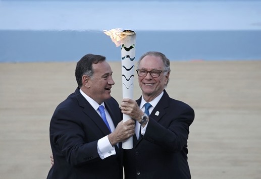 Spyros Capralos, head of the Hellenic Olympic Committee (L), hands over an Olympic torch to Riou2019s Olympic chief Carlos Nuzman during the handover ceremony of the Olympic Flame to the delegation of the 2016 Rio Olympics, at the Panathenaic Stadium in Athens yesterday. (Reuters)