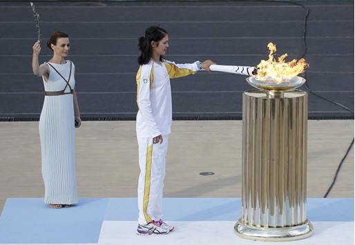 Greek rowing World Champion Katerina Nicolaidou lights a cauldron with the Olympic Flame during the handover ceremony of the Olympic Flame to the delegation of the 2016 Rio Olympics, at the Panathenaic Stadium in Athens. (Reuters)