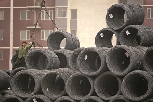 A labourer works on coils of steel wire at a steel wholesale market in Beijing. Industrial profits in China rose to 561.24bn yuan ($86.50bn) in March, the National Bureau of Statistics said on its website yesterday.