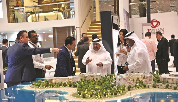 Participants look at a model being displayed at Cityscape Qatar.